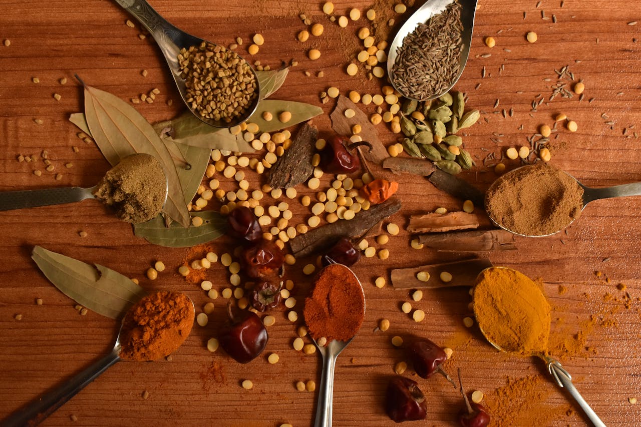 about-img A vibrant display of various Indian spices arranged creatively on a wooden table.