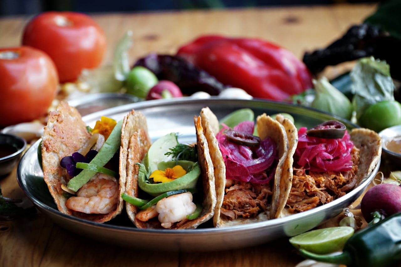 services-01 Colorful Mexican tacos with shrimp and shredded meat garnished with vibrant vegetables.