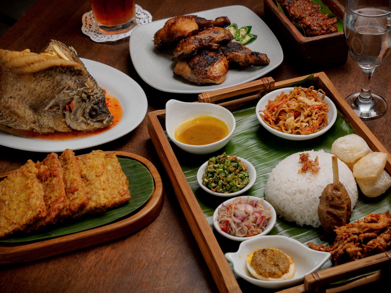 services-02 Discover a delicious array of traditional Indonesian dishes beautifully presented on a wooden table.