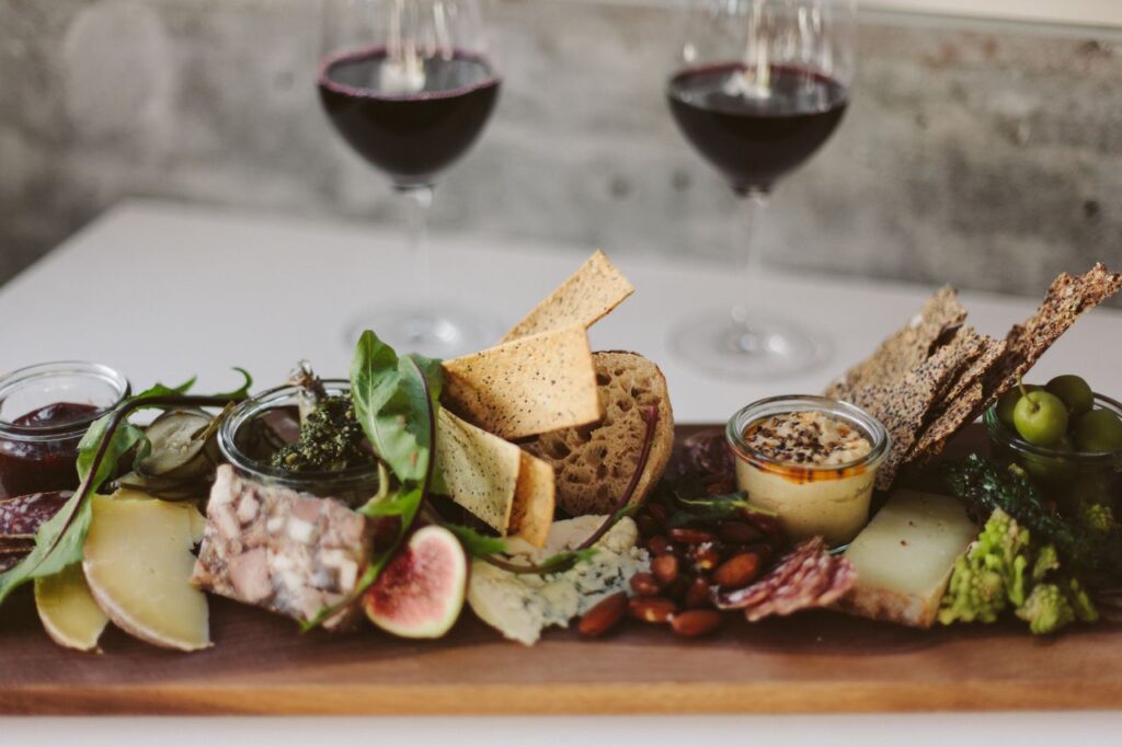 A gourmet charcuterie board paired with red wine, ideal for fine dining.